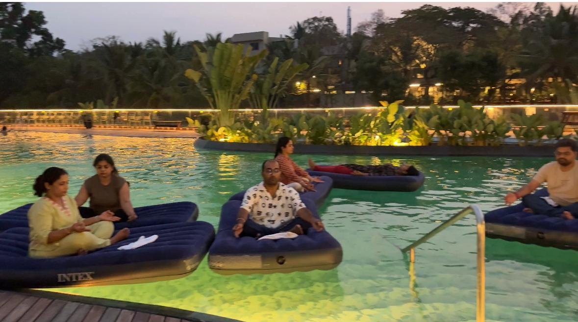 Attendees floating in meditation on the water during an aqua sound bath